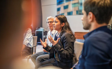 Woman gesturing with her hands next to colleagues